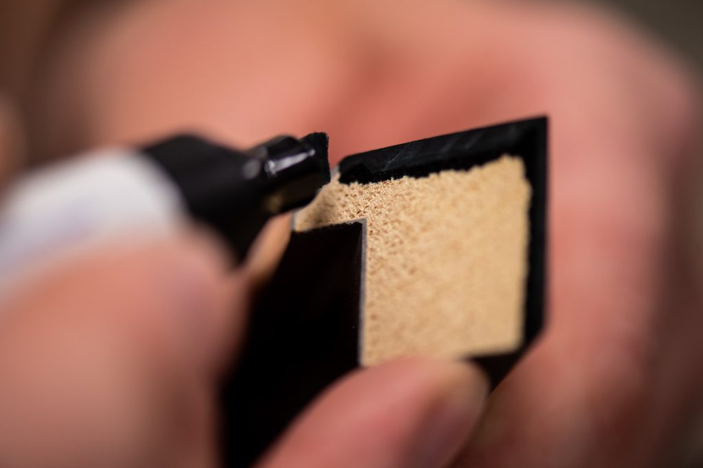 Colouring the inside edge of a moulding with a touch up pen, to hide the natural wood finish