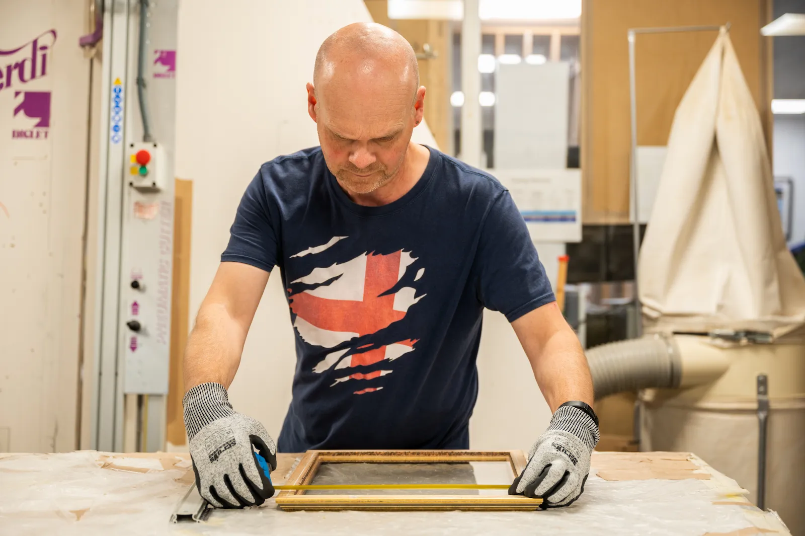 A member of the framing team preparing to reglaze a frame