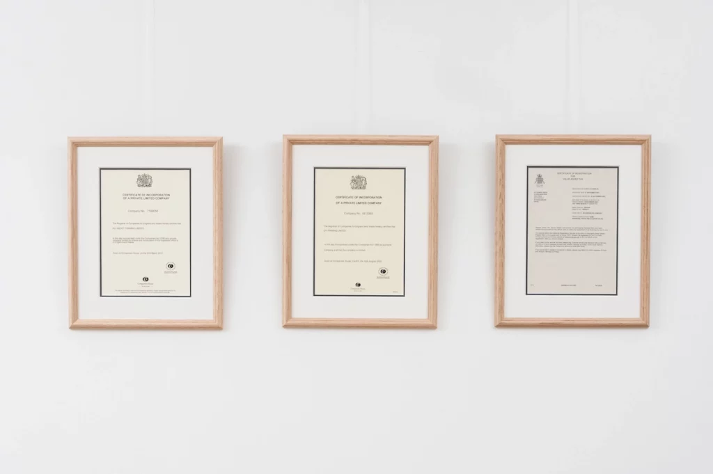 Three documents framed and displayed on a wall