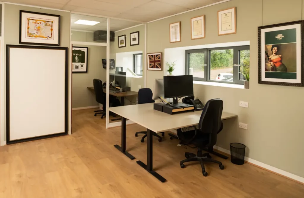An office space showing examples of framed fabrics, shirts, posters, documents, photos and a framed whiteboard
